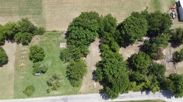 an aerial view of residential house with outdoor space and trees all around