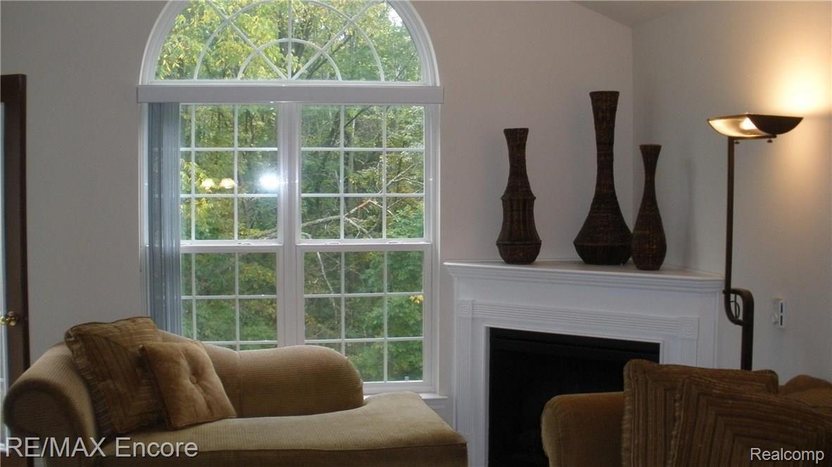 3567 Tremonte Circle, Unit 243 Rochester, MI 48306 - Photo 11 of 23 gas fireplace and doorway to balcony add ambiance