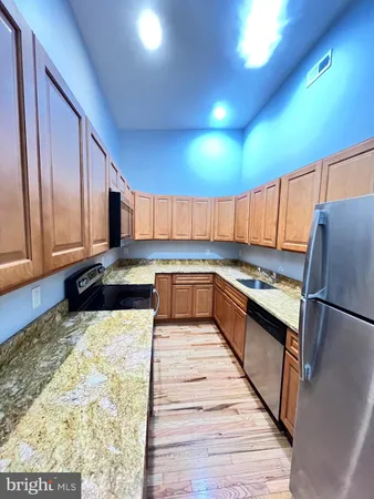 a large kitchen with a large counter top space stainless steel appliances and cabinets