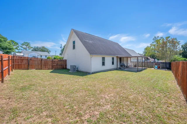 a backyard of a house with table and chairs