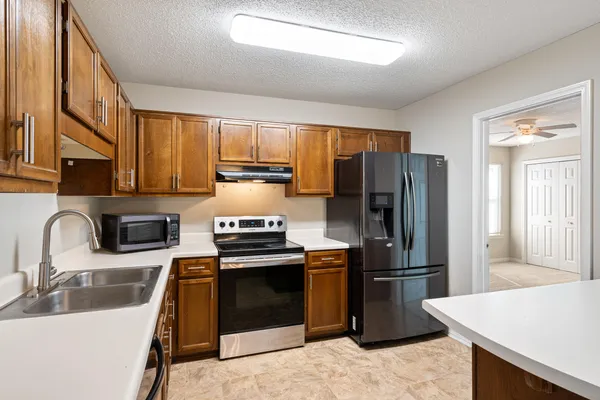 an empty room with windows and fan