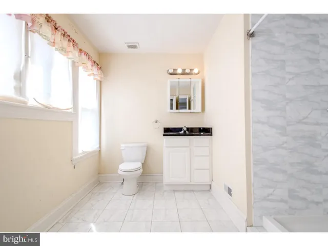 a bathroom with a toilet a sink and a window