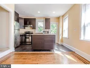 a view of kitchen with stainless steel appliances granite countertop a stove top oven a sink and a refrigerator