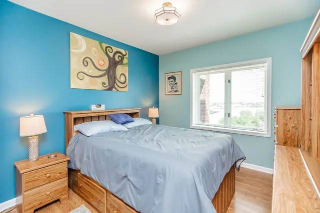 a bedroom with a bed and a lamp on dresser