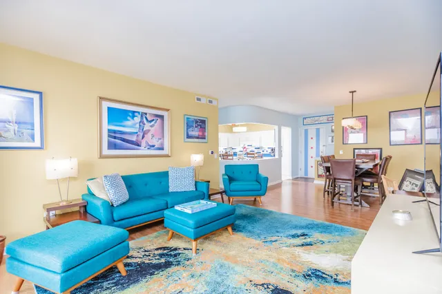 a living room with furniture a rug and a dining table