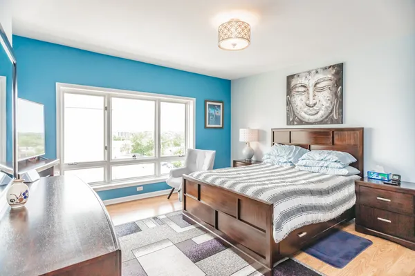 a bedroom with a large bed and a lamp on table with a large window