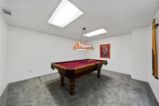 a room with pool table and windows