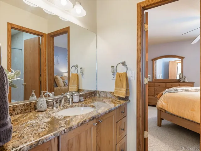 a en suite bathroom with a granite countertop sink and a mirror