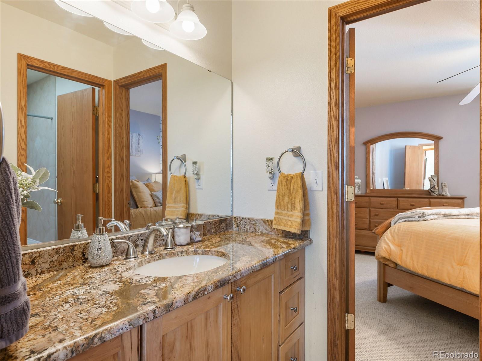 76 Raven Rdg Road Idaho Springs, CO 80452 - Photo 22 of 49 a en suite bathroom with a granite countertop sink and a mirror
