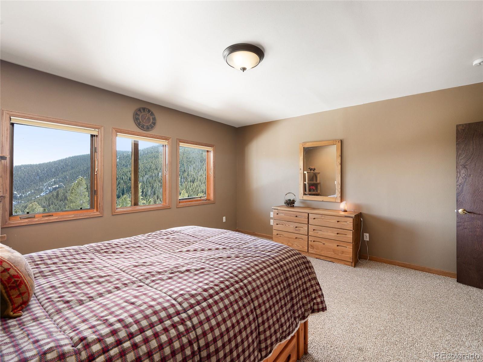 76 Raven Rdg Road Idaho Springs, CO 80452 - Photo 28 of 49 a bedroom with a large bed and a window