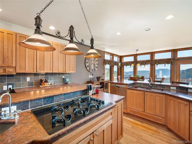 a kitchen with stainless steel appliances granite countertop a stove a sink dishwasher and cabinets with wooden floor