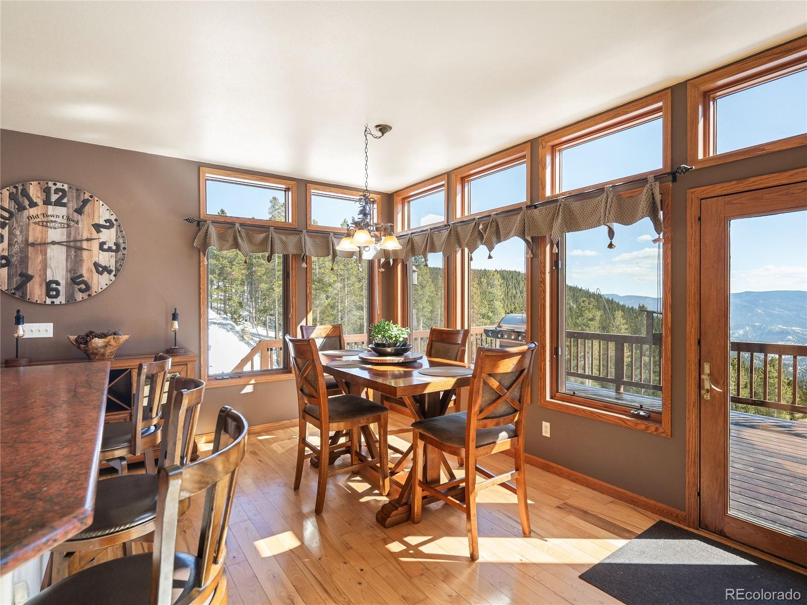 76 Raven Rdg Road Idaho Springs, CO 80452 - Photo 9 of 49 a view of a dining room with furniture large windows and wooden floor