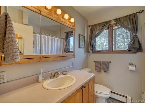 a bathroom with a sink vanity mirror and toilet