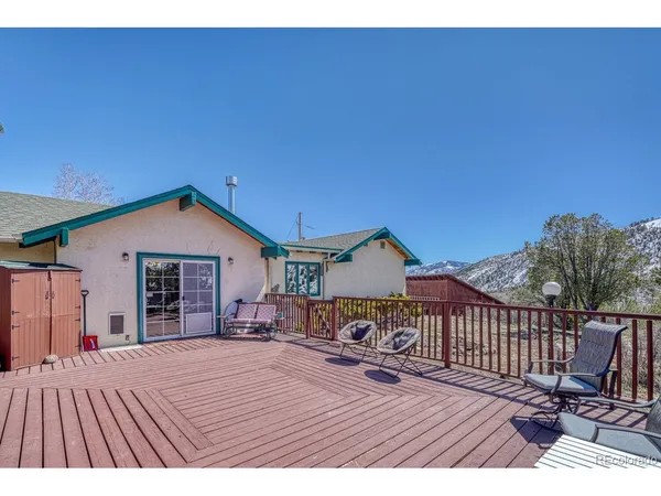 a view of a house with wooden deck and furniture
