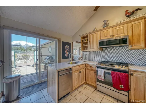 a kitchen with stainless steel appliances granite countertop a stove a sink dishwasher and cabinets with wooden floor