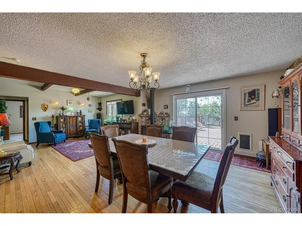 a view of a dining room with furniture a chandelier and wooden floor