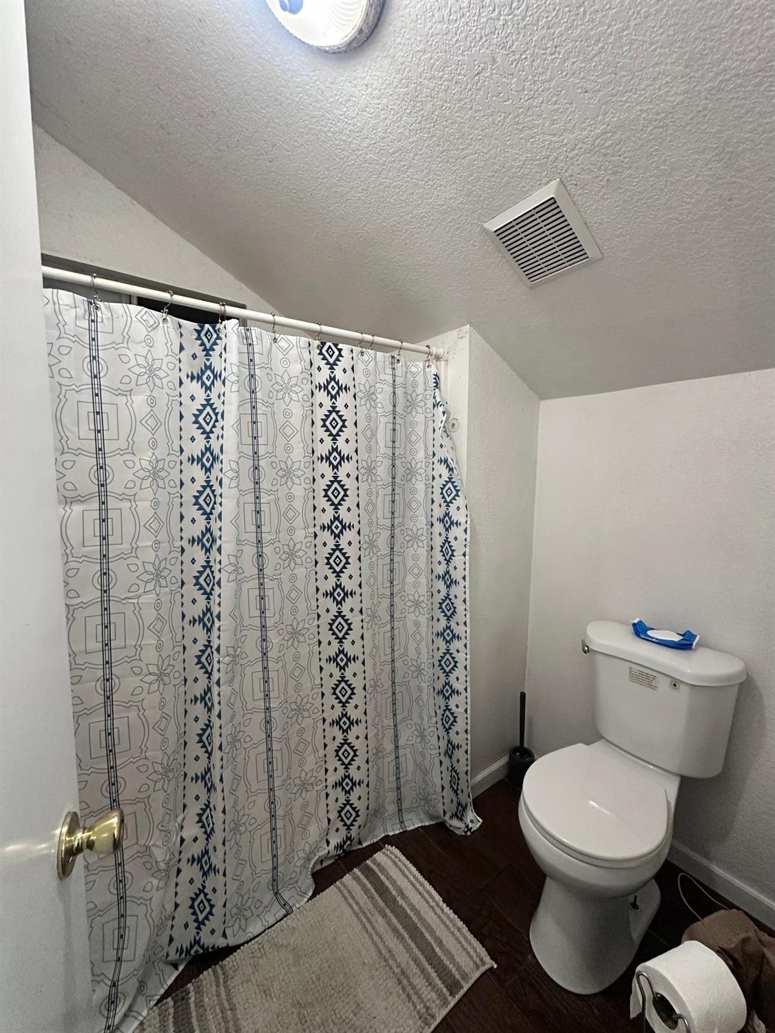 3608 Cassie Lane Ceres, CA 95307 - Photo 20 of 25 a white toilet sitting next to a shower curtain