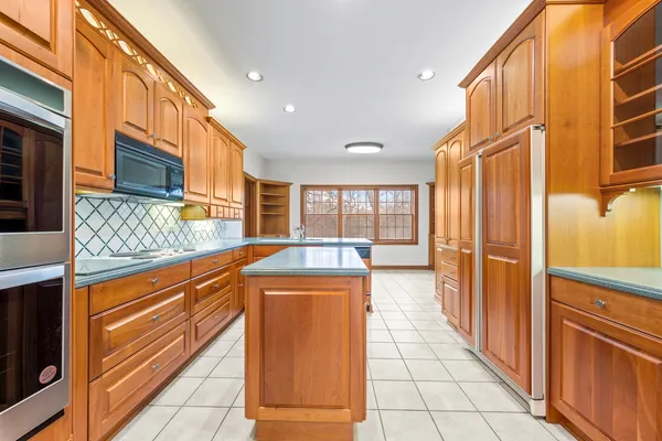 a kitchen with stainless steel appliances granite countertop a sink counter space and a refrigerator