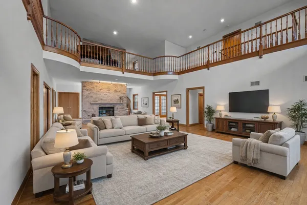 an empty room with wooden floor fireplace and windows
