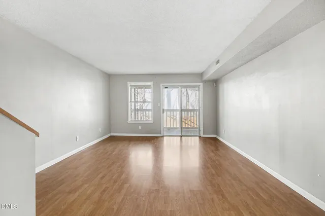 a view of empty room with wooden floor