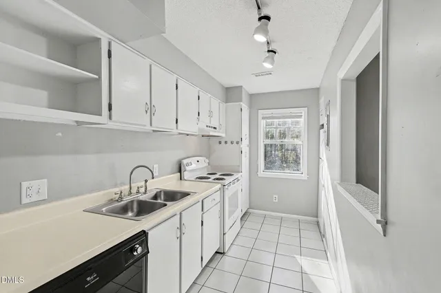 a kitchen with a sink a stove and cabinets