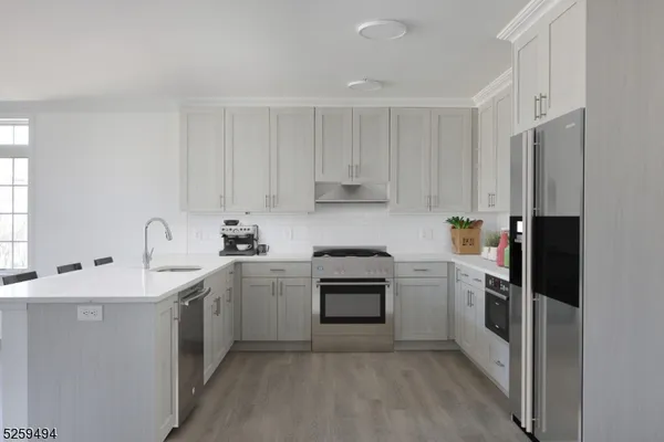 a kitchen with cabinets stainless steel appliances and sink