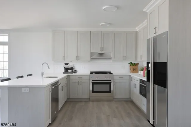 a kitchen with cabinets stainless steel appliances and sink