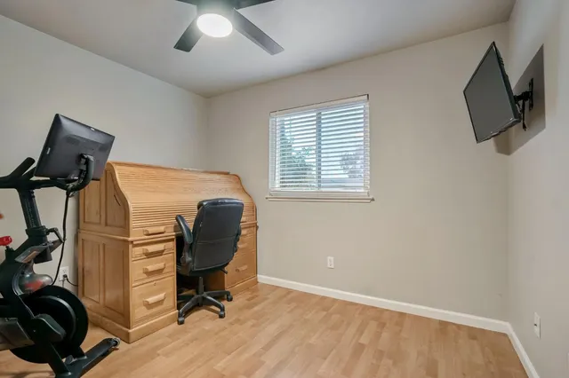 a view of a workspace with furniture and a window