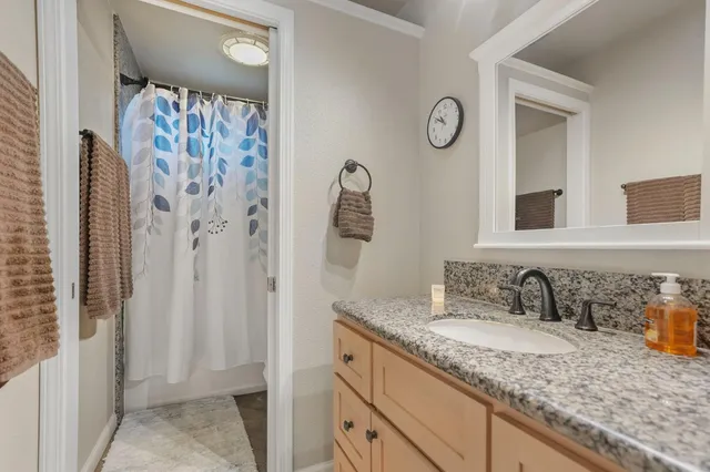 a bathroom with a granite countertop sink and a mirror