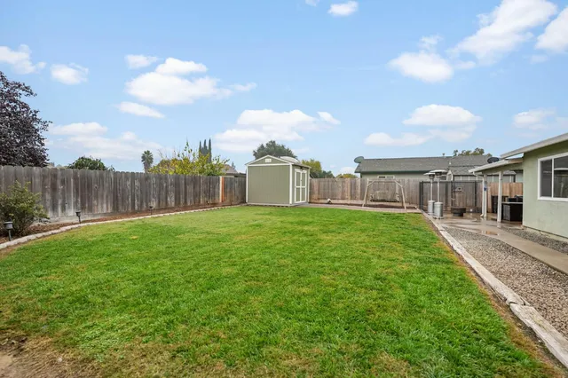 a view of a yard in front of a house with a large tree