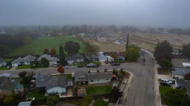 an aerial view of a city with lots of residential buildings ocean and mountain view in back