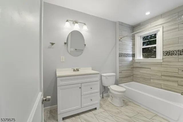 a bathroom with a toilet a sink a mirror a bathtub and shower