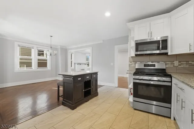 a kitchen with stainless steel appliances granite countertop a stove and a microwave