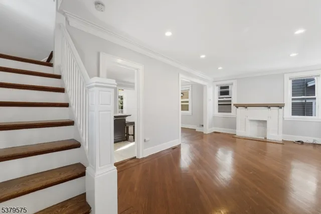 a view of a kitchen with wooden floor and a fireplace