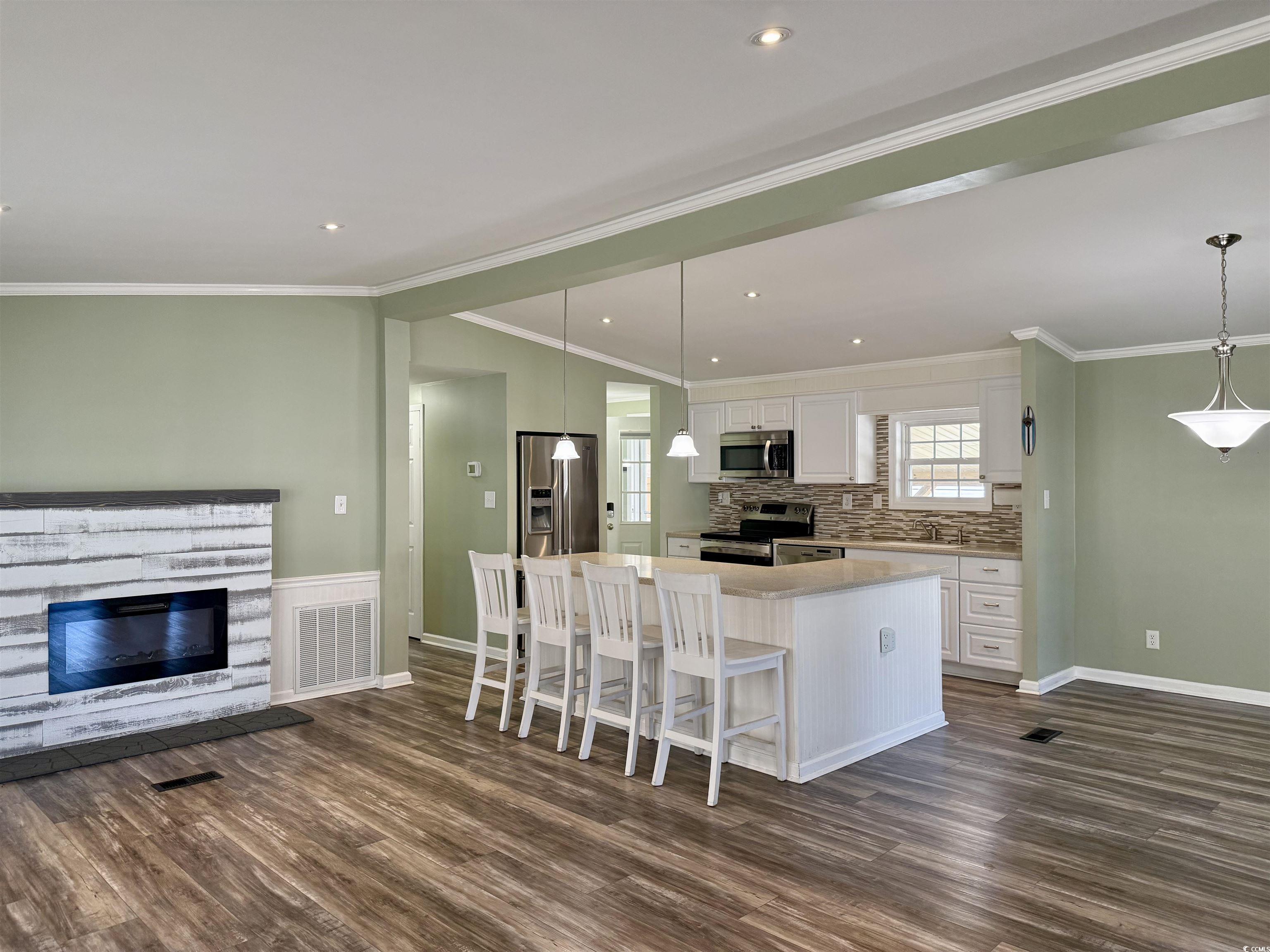 465 Sandpebble Surfside Beach, SC 29575 - Photo 40 of 40 Kitchen with white cabinets, appliances with stainless steel finishes, open floor plan, a kitchen bar, and pendant lighting