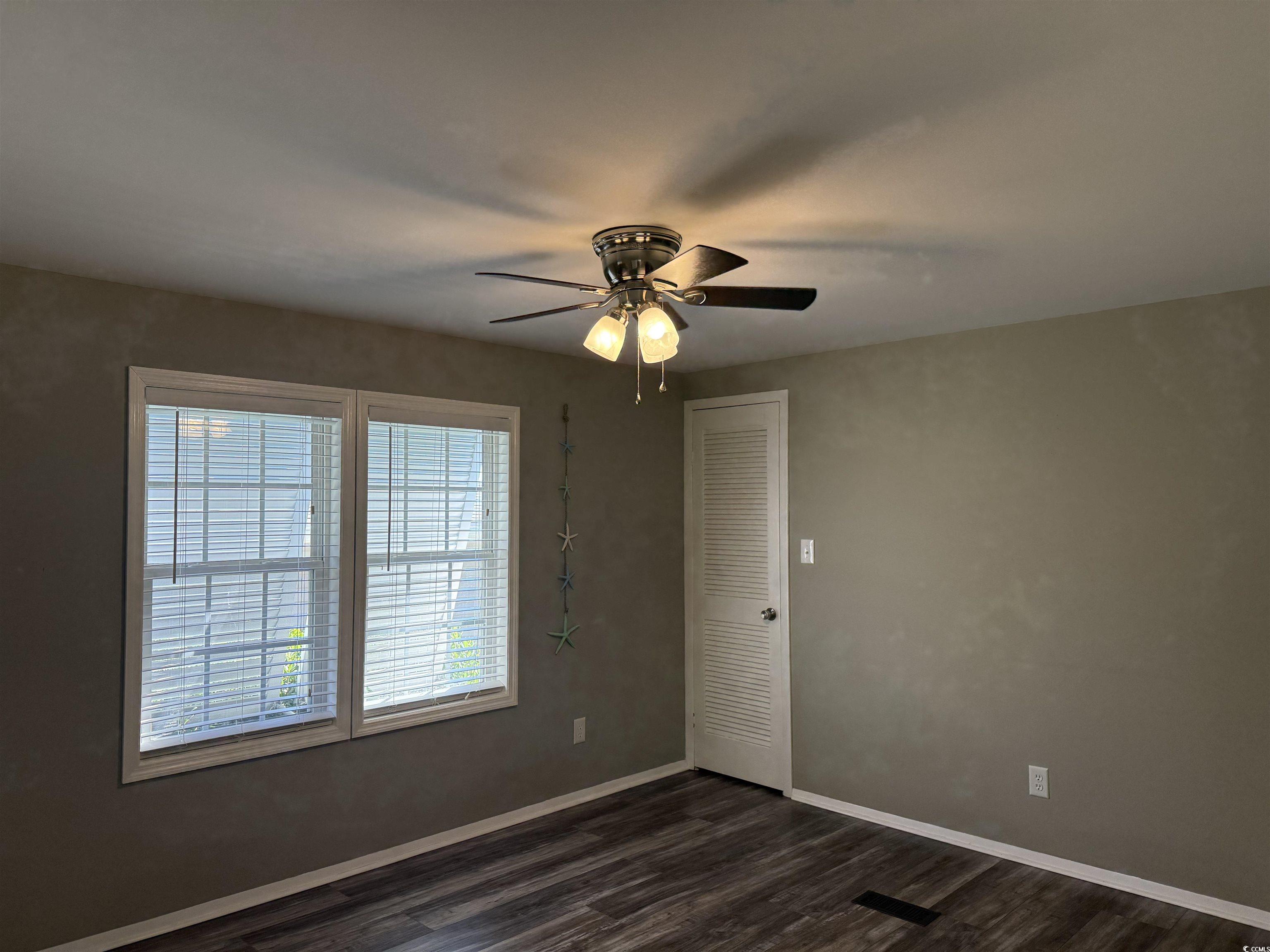 465 Sandpebble Surfside Beach, SC 29575 - Photo 11 of 40 Unfurnished room with dark wood-style floors and a ceiling fan