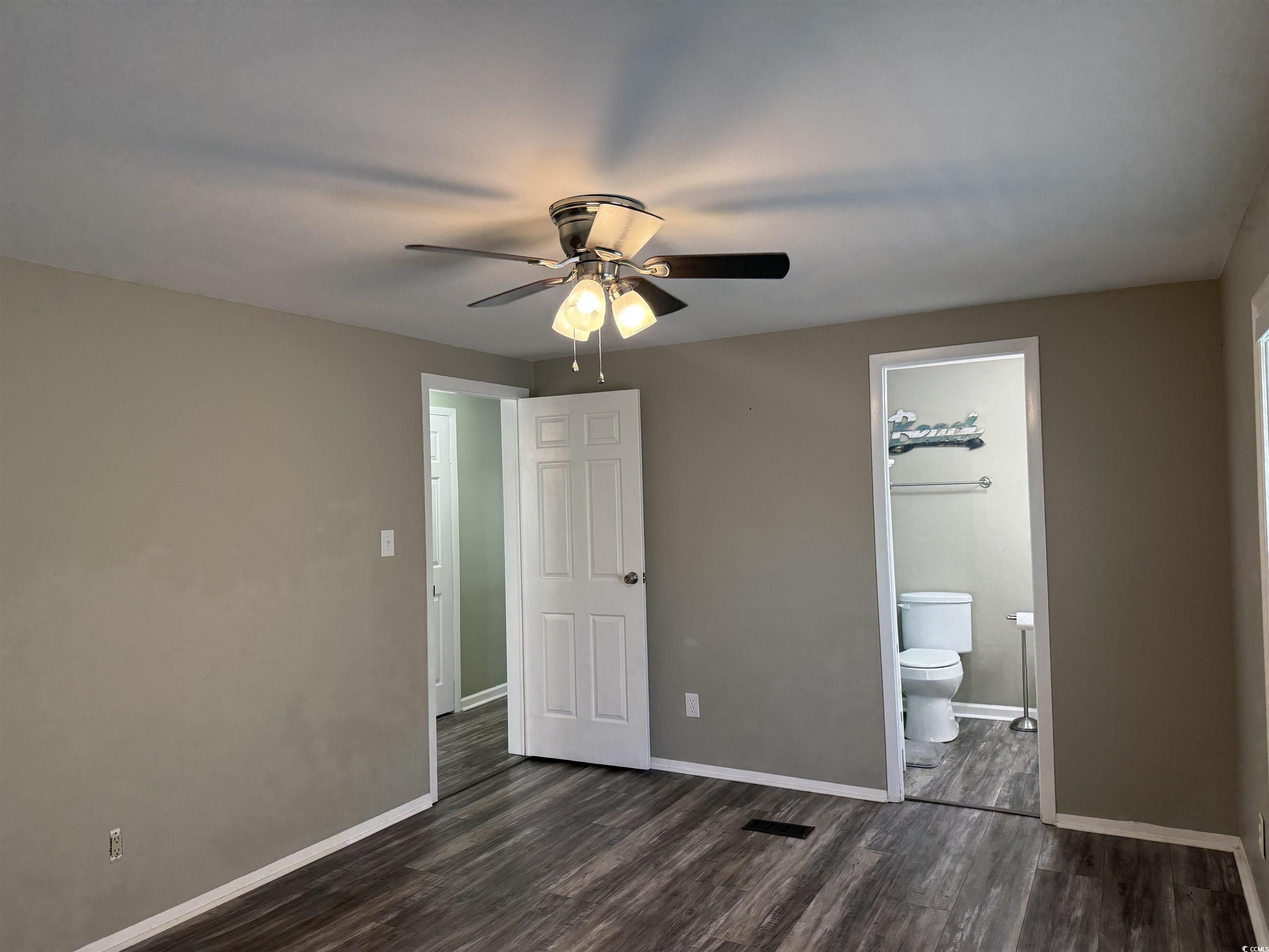 465 Sandpebble Surfside Beach, SC 29575 - Photo 15 of 40 Unfurnished bedroom with dark wood finished floors, a ceiling fan, and connected bathroom
