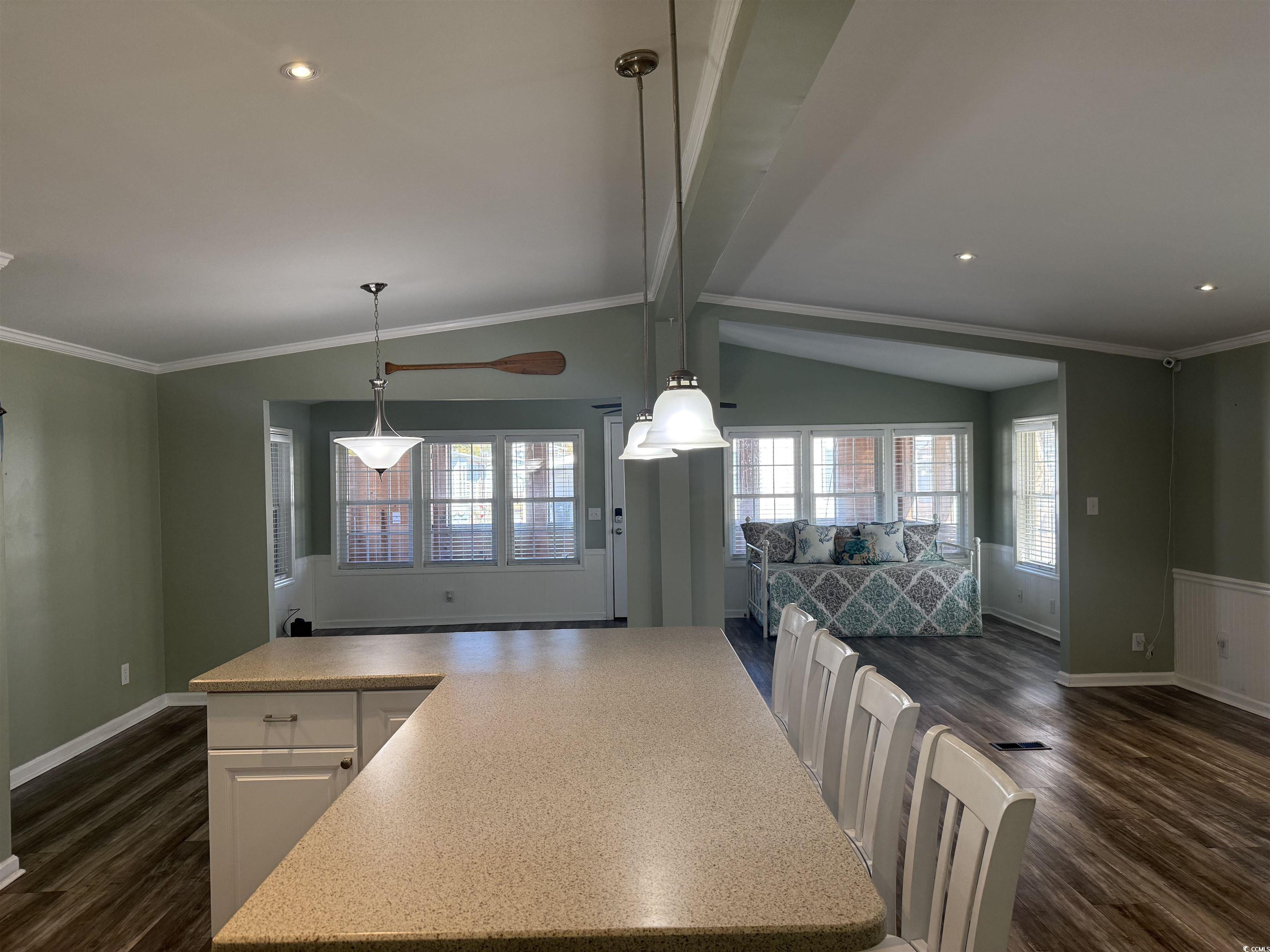 465 Sandpebble Surfside Beach, SC 29575 - Photo 39 of 40 Kitchen featuring dark wood finished floors, open floor plan, ornamental molding, white cabinets, and light countertops