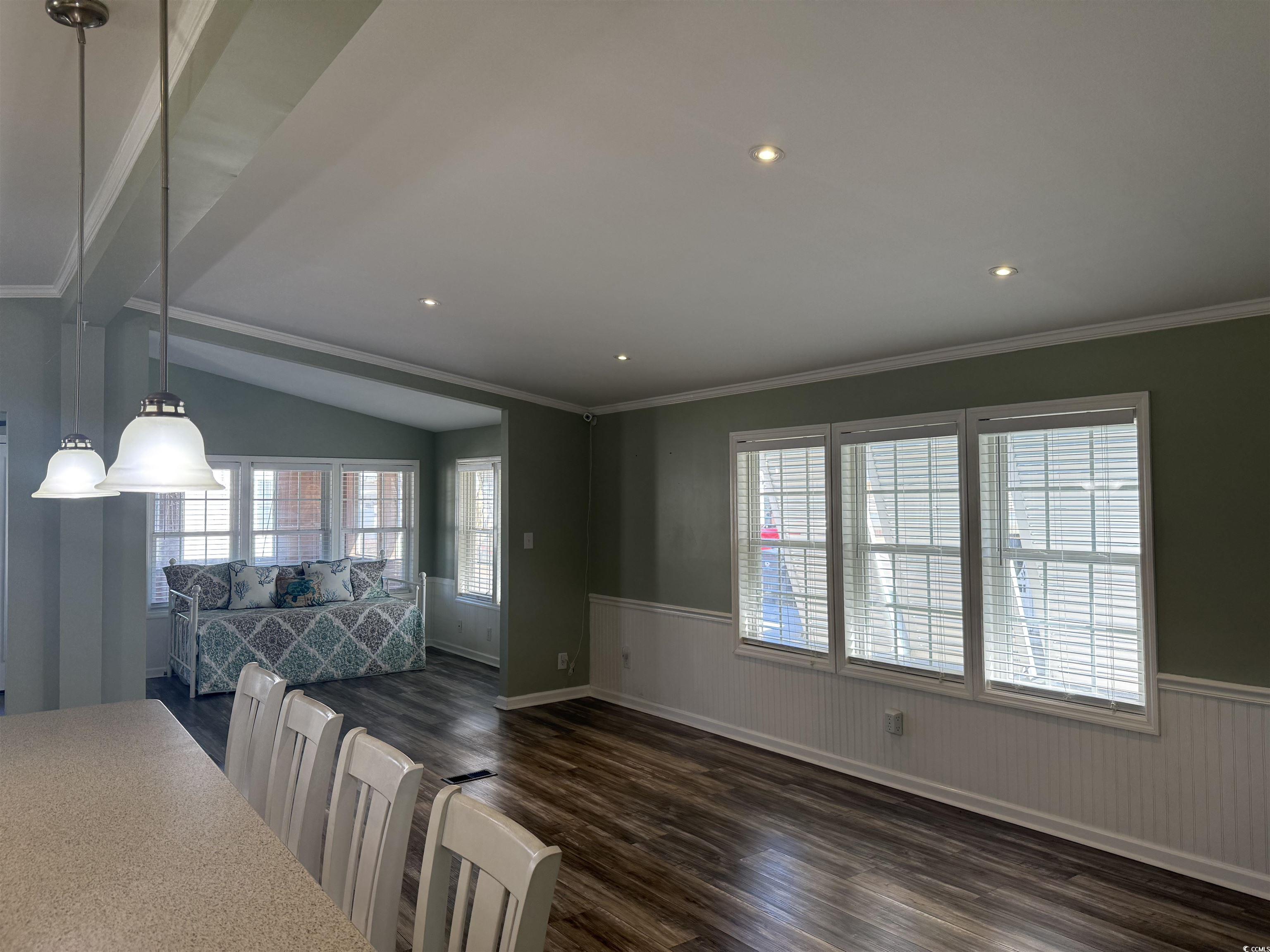 465 Sandpebble Surfside Beach, SC 29575 - Photo 3 of 40 Dining room with dark wood-style floors, wainscoting, ornamental molding, recessed lighting, and lofted ceiling