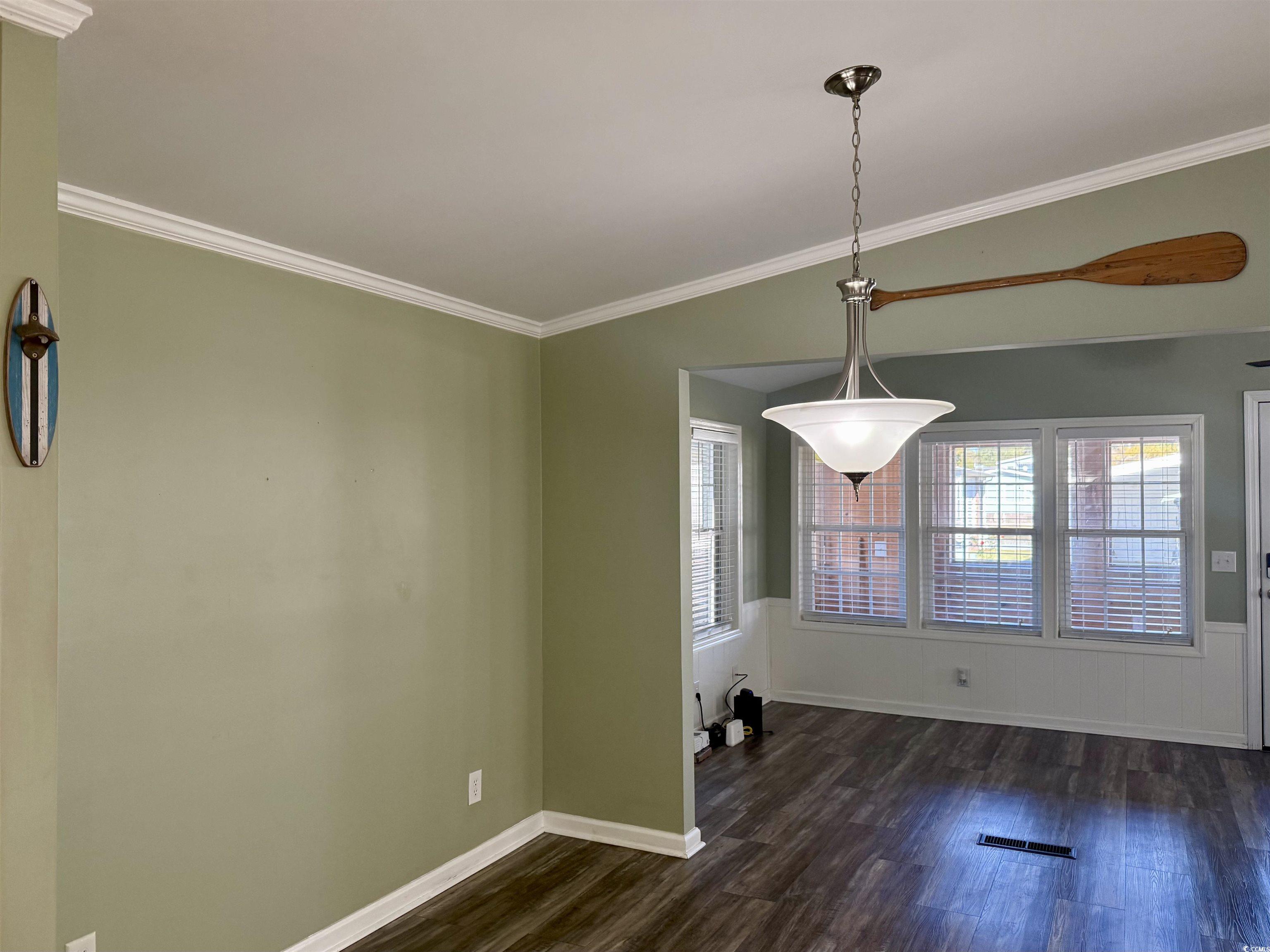 465 Sandpebble Surfside Beach, SC 29575 - Photo 6 of 40 Unfurnished dining area featuring crown molding and dark wood-type flooring