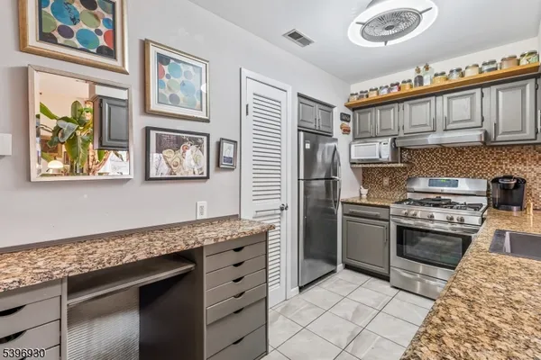 a kitchen with stainless steel appliances granite countertop a stove a sink dishwasher and a refrigerator