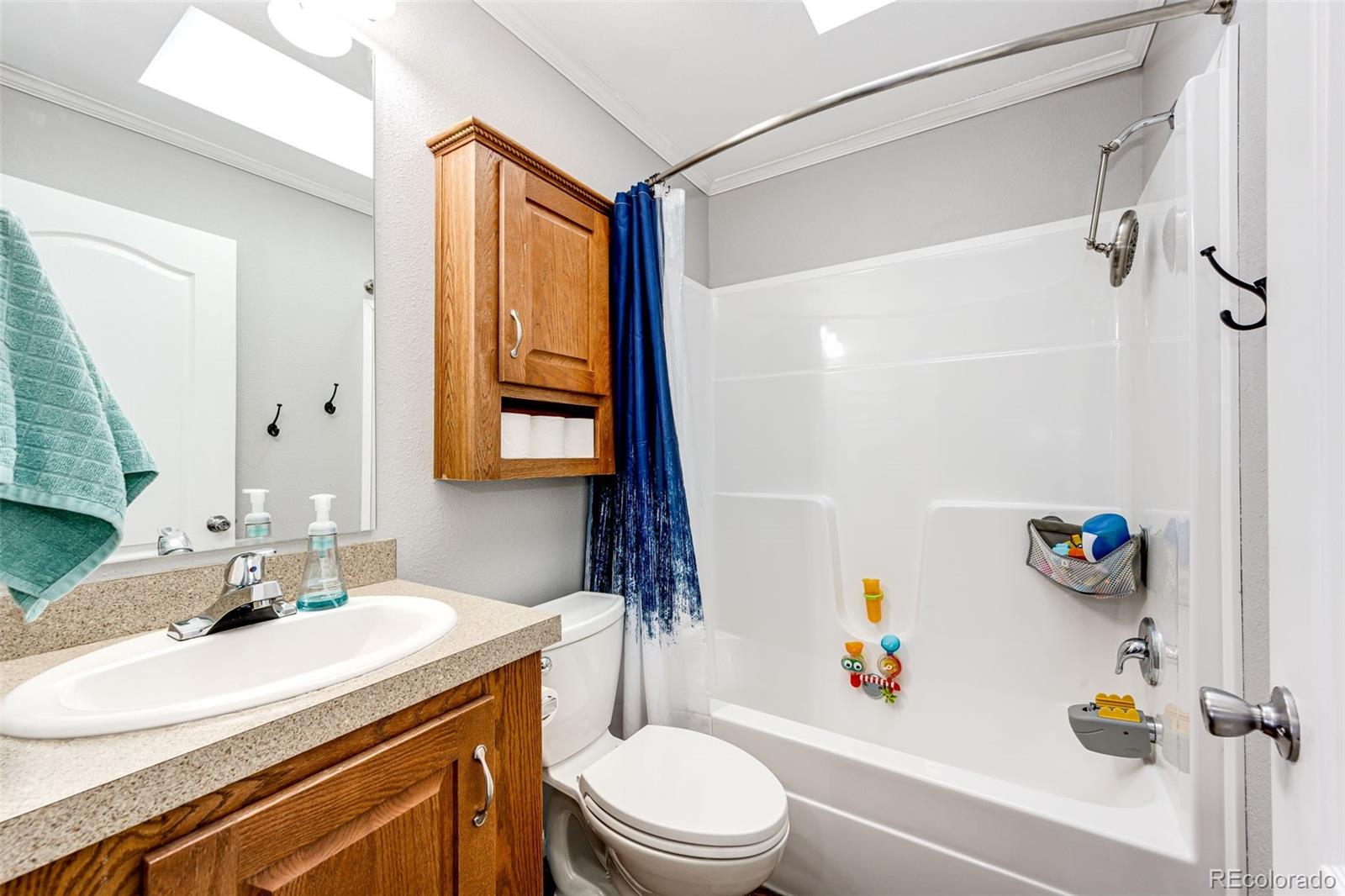 570 4th Street Bennett, CO 80102 - Photo 19 of 36 a bathroom with a sink toilet vanity and shower
