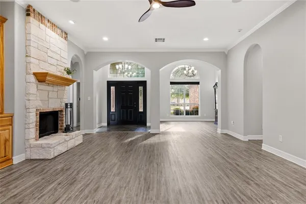an empty room with windows and fireplace
