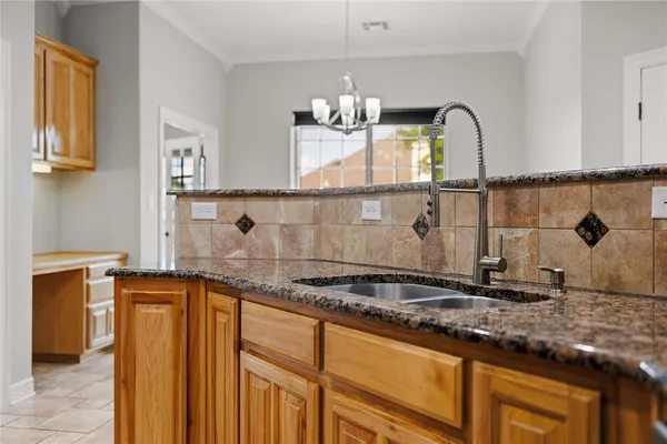 a kitchen with granite countertop a sink stainless steel appliances and cabinets