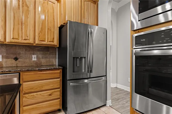 a kitchen with stainless steel appliances granite countertop a refrigerator and a stove