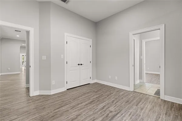 an empty room with wooden floor & closet area