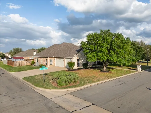 swimming pool view with large trees and wooden fence