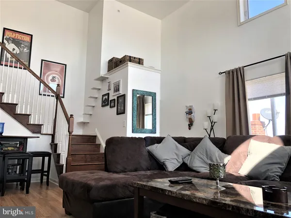 a living room with furniture kitchen view and a window