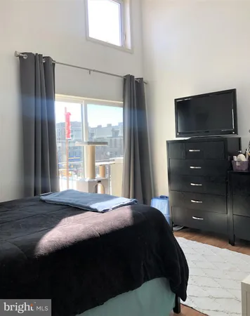 a bedroom with a bed and a flat tv screen on dresser