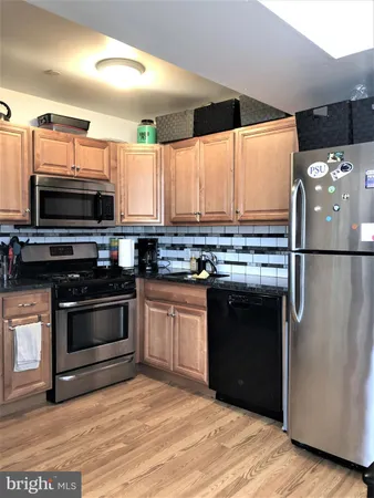 a kitchen with stainless steel appliances kitchen island granite countertop a stove a sink and a microwave